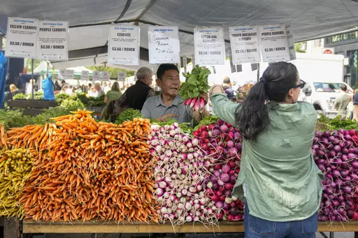 A vendor helps a customer at a produce stand at the Union Square farmers market, Saturday, June 17, 2023, in New York. Small vendors at farmers markets say the 2023 season is shaping up to be strong, as farmers market continue to benefit from swells of regular customers that grew during the pandemic and new vendors stalls that started during the pandemic. (AP Photo/Mary Altaffer)