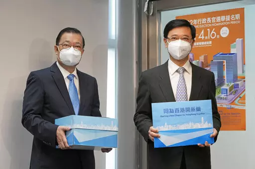 Former Hong Kong Chief Secretary John Lee, right, and his supporter Tam Yiu-chung, Hong Kong's representative to the Standing Committee of China's National People's Congress, pose for a photograph before submitting Lee's candidacy for the Election of the Chief Executive, in Hong Kong, Wednesday, April 13, 2022. Hong Kong’s former No. 2 official Lee said Wednesday he had formally registered his candidacy in the election for the top job after securing 786 nominations to enter the race.(AP Photo/