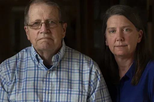 William Bortz, left, stands alongside his daughter, Ave Williams, at his senior living center, Friday, May 17, 2024, in San Diego. Bortz said criminals stole his family's nest egg of almost $700,000 in an elaborate scheme. Sophisticated overseas criminals are stealing tens of billions of dollars from Americans every year, a crime wave that's projected to get worse as the U.S. population ages and technology like AI makes it easier than ever to perpetrate fraud and get away with it. (AP Photo/Greg