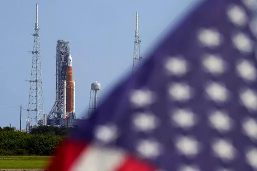 An American flag flies in the breeze as NASA's new moon rocket sits on Launch Pad 39-B after being scrubbed at the Kennedy Space Center Sept. 3, 2022, in Cape Canaveral, Fla.  It’s not just rocket fuel propelling America’s first moonshot after a half-century lull. Rivalry with China’s space program is helping drive NASA’s effort to get back into space in a big way. That's as both nations push to put people back on the moon and establish the first lunar bases. (AP Photo/Chris O'Meara, Fil