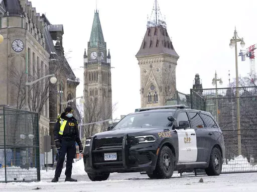 A police officer mans a checkpoint near Parliament Hill, Wednesday, Feb. 23, 2022 in Ottawa. Ottawa protesters who vowed never to give up are largely gone, chased away by police in riot gear in what was the biggest police operation in the nation’s history.  (Adrian Wyld /The Canadian Press via AP)