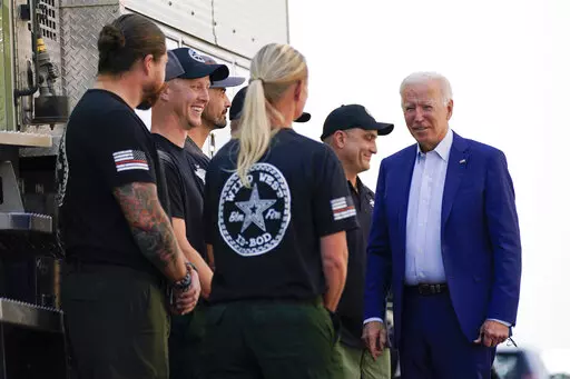 President Joe Biden greets firefighters as he tours the National Interagency Fire Center, Sept. 13, 2021, in Boise, Idaho. Biden on June 21, 2022, signed off on giving federal wildland firefighters a hefty raise for the next two fiscal years, a move that comes as much of the West is bracing for a difficult wildfire season. (AP Photo/Evan Vucci, File)