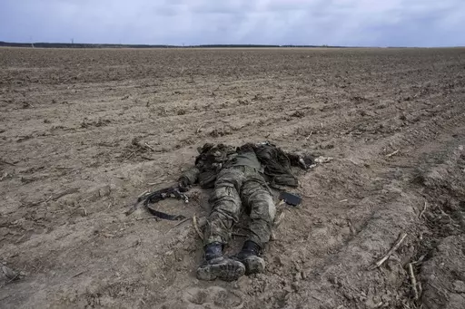 A Russian soldier killed during combats against Ukrainian army lies on a corn field in Sytnyaky, on the outskirts of Kyiv, Ukraine, Sunday, March 27, 2022. Nearly 50,000 Russian soldiers have died in the war in Ukraine, according to a new statistical analysis. (AP Photo/Rodrigo Abd, File)