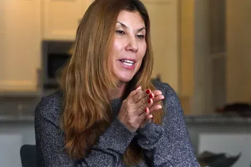 Attorney Mary Bluma, a single parent, talks about having her two children back home instead of in school Thursday, Jan. 6, 2022, in Chicago. Hundreds of thousands of Chicago students remained out of school for a second straight day Thursday after leaders of the nation's third-largest school district failed to resolve a deepening clash with the influential teachers union over COVID-19 safety protocols. (AP Photo/Charles Rex Arbogast)