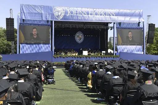 In this handout photo released by Johns Hopkins University, Ukrainian President Volodymyr Zelenskyy addresses the graduating class of Johns Hopkins University via livestream from Ukraine, Thursday, May 25, 2023, in Baltimore, Md. (Will Kirk/Johns Hopkins University via AP)