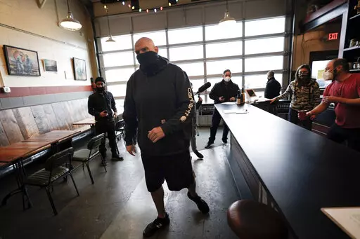 Democratic candidate for the Pennsylvania U.S.senate seat in the 2022 primary election, Lt. Gov. John Fetterman, arrives for a campaign stop at the Mechanistic Brewery, in Clarion, Pa., Saturday, Feb. 12, 2022. The Democratic Party's brand is so toxic in some parts of rural America that liberals are removing bumper stickers and refusing to acknowledge their party affiliation publicly.  (AP Photo/Keith Srakocic)