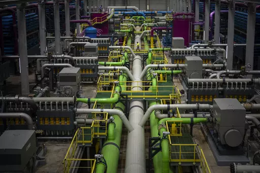 A worker walks over the pipeline that transports seawater to filters at Europe's largest desalination plant for drinking water located in Barcelona, Spain, Tuesday, May 16, 2023. Europe's largest desalination plant for drinking water had largely remained idle since its construction near Barcelona over a decade ago. But since a prolonged drought gripped Spain, the plant has been running at full throttle. (AP Photo/Emilio Morenatti)