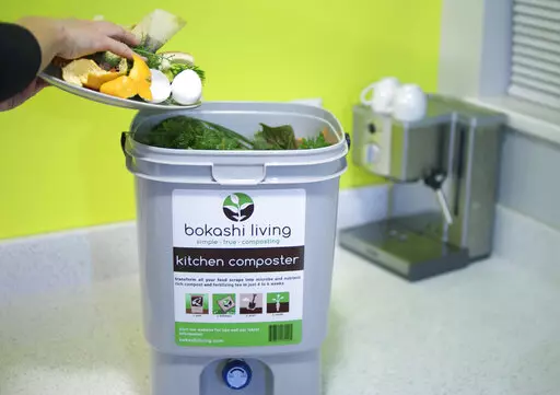 This image provided by Bokashi Living shows kitchen scraps being added to a bokashi composting bucket. (bokashiliving.com via AP)