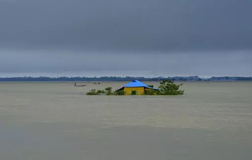 A house stands surrounded by floodwaters in Sylhet, Bangladesh, Monday, June 20, 2022. Early and strong monsoon rains have brought heavy flooding to northeastern India and Bangladesh, killing dozens of people, forcing hundreds of thousands from their homes and cutting millions off from crucial supplies. (AP Photo/Mahmud Hossain Opu)