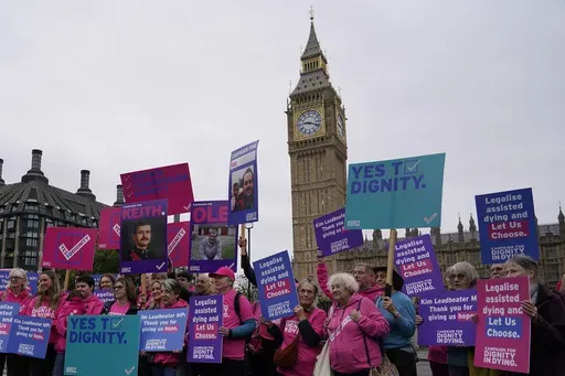 A small demonstration by people advocating assisted dying hold a protest outside the Hoses of Parliament as a bill to legalise assisted dying is to be put before lawmakers in London, England, Oct. 16, 2024. (AP Photo/Alberto Pezzali, File)