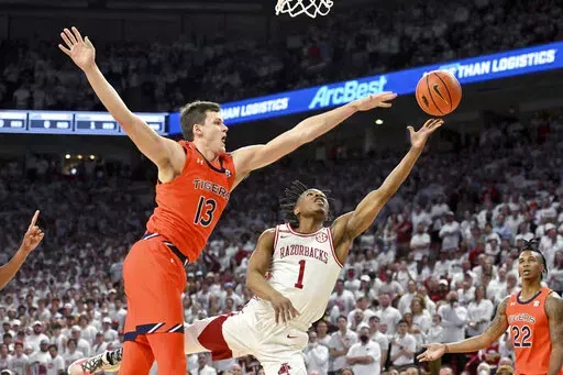 Arkansas guard JD Notae (1) drives past Auburn forward Walker Kessler (13) to score during the first half of an NCAA college basketball game Tuesday, Feb. 8, 2022, in Fayetteville, Ark. (AP Photo/Michael Woods)