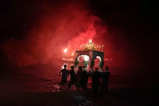 Men carry into the sea the "Epitaph", the procession of Jesus' funeral bier in the seaside town of Tolo, about 150 kilometres (94 miles) southwest of Athens, Greece, Friday, April 14, 2023. About 300 million Orthodox Christians around the world will celebrate Easter on Sunday, April 16, the most important religious holiday in the Orthodox Christian calendar. (AP Photo/Thanassis Stavrakis)